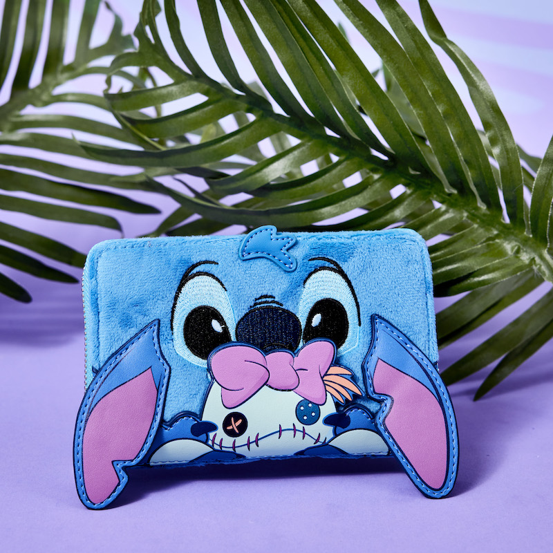 Image of the plush Stitch and Scrump wallet featuring Stitch holding Scrump, against a purple background with leaves